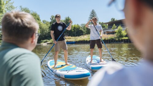 Zwei Personen stehen auf dem Standup-Paddleboard auf der Saale