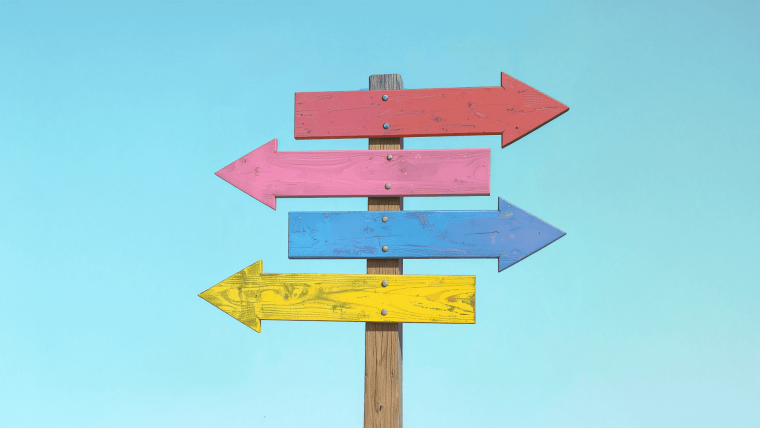 Ein Wegweiser mit bunten Pfeilen zeigt in unterschiedliche Richtungen.
