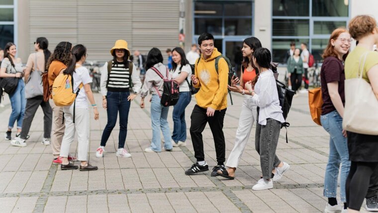 Gruppe Studierende laufen über Campus