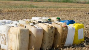 Jerry cans with glyphosate standing on a field